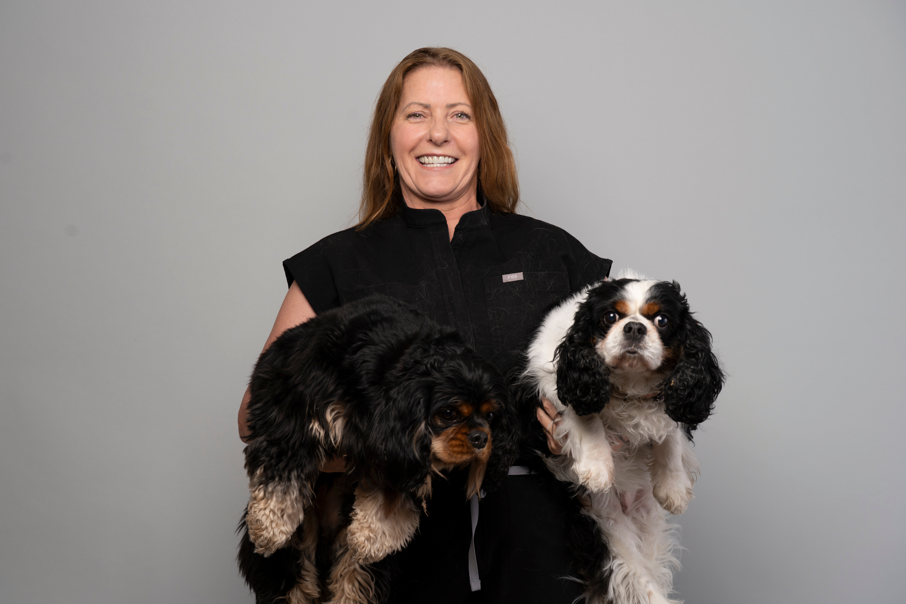 Sandy holding two Cavalier King Charles Spaniels