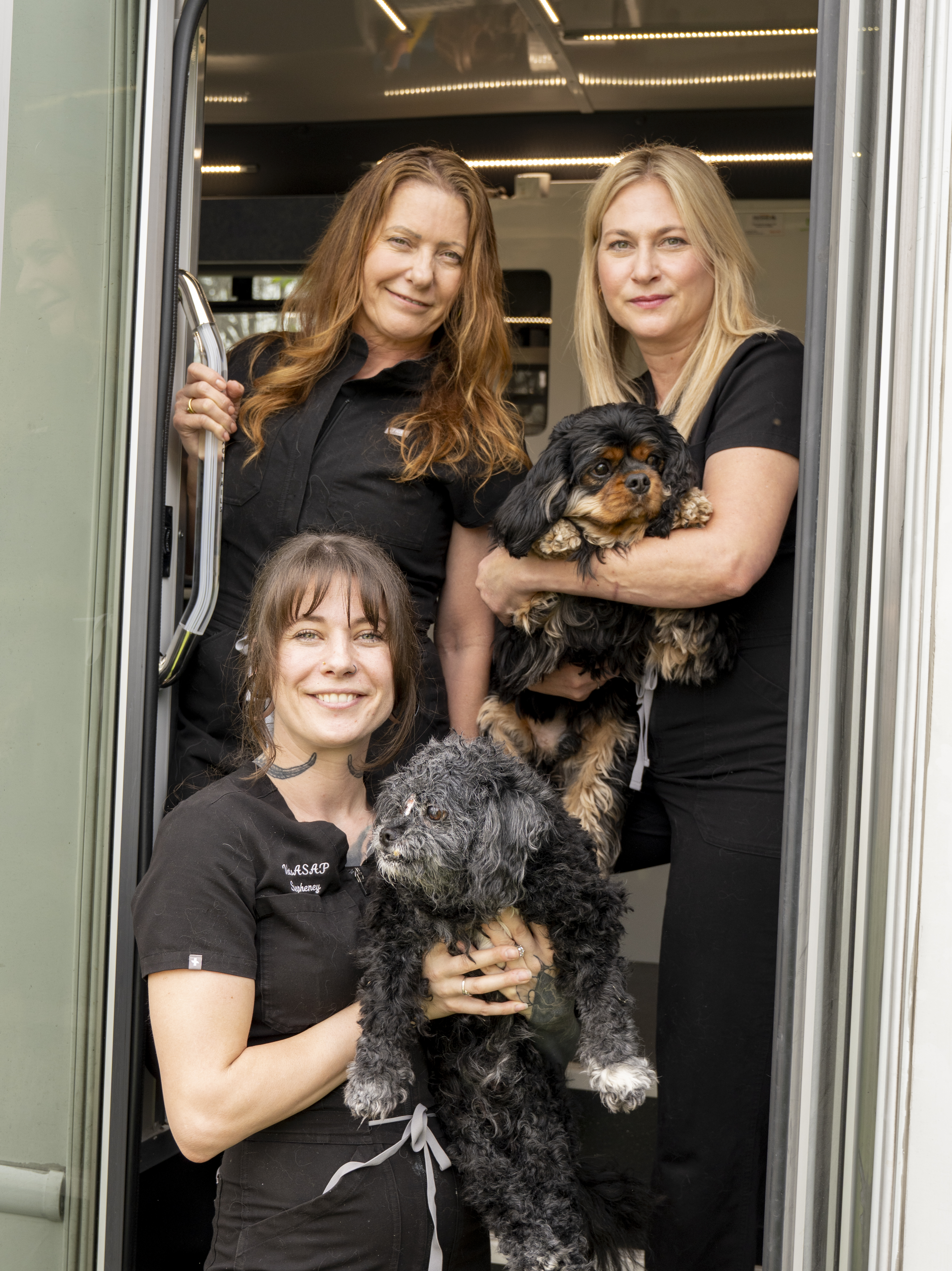 Dr. Caren and Stepheney with their dogs at the van doorway